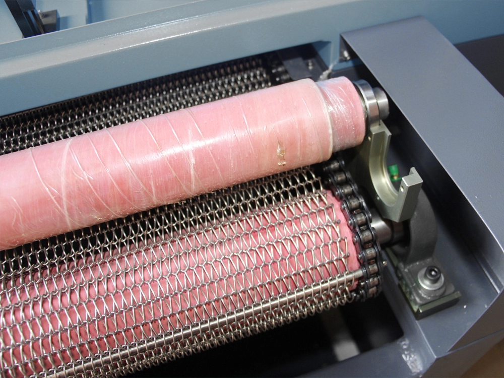 Pressure rollers above the conveyor belt