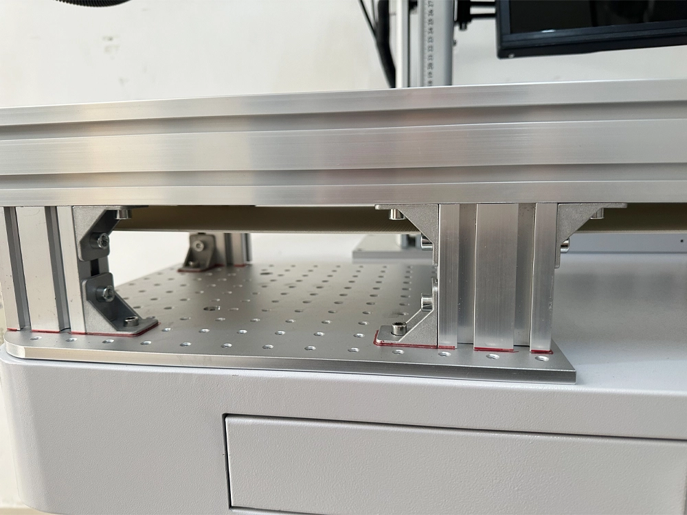 The conveyor belt is fixed to the standard perforated worktable with bolts